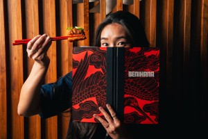 a woman holding a piece of food and a book