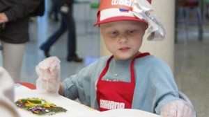 a boy wearing a red hat and apron