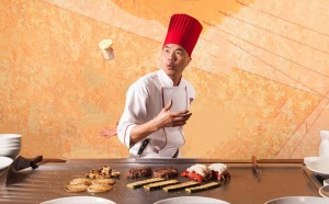 a man in a chef's hat throwing food into the air