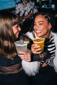 two women holding drinks